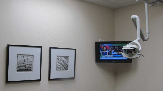 dentistry exam room with tv on wall