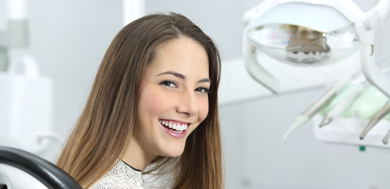young woman smiling in dentist chair