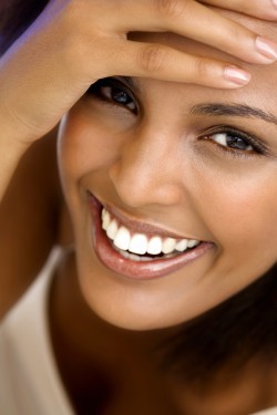 young woman smiling up at camera with perfect smile
