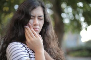 Photo by Andrea Piacquadio: https://www.pexels.com/photo/shallow-focus-photo-of-woman-in-white-and-black-stripe-shirt-3808804/ – woman with a toothache