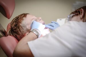 Image by Michal Jarmoluk from Pixabay https://pixabay.com/photos/dentist-patient-dental-care-medical-428646/ -- boy during a dental exam