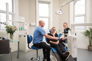 https://pixabay.com/photos/all-on-4-dental-implants-belfast-8378579/ Woman with dentists admiring her smile